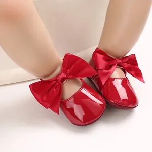 Vista detallada de zapatos para bebé de charol rojo brillante con un gran lazo de satén