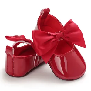Vista detallada de zapatos de princesa rojos de charol para bebé con lazo grande