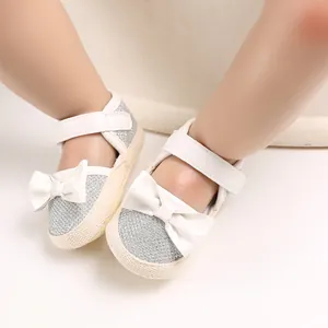 Detailed macro view of baby princess walking shoes with silver glitter and white bow