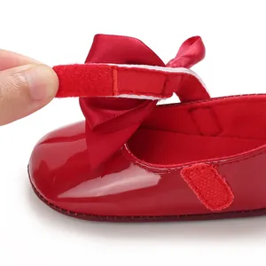 Primer plano del cierre de velcro ajustable en un zapato rojo para bebé niña.
