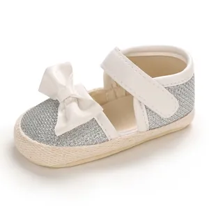 Detailed view of baby princess walking shoes with silver glitter and white bow