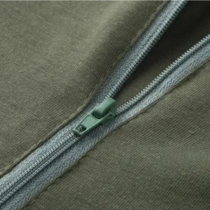 Macro detail of high-quality zipper and ribbed fabric texture on olive green men's jumpsuit