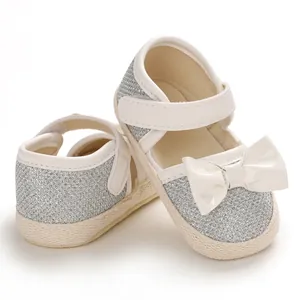 Detail of silver glitter baby princess walking shoes with white bow and soft sole