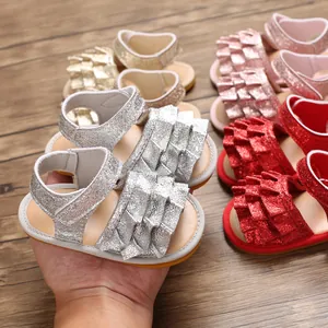 Nahaufnahme von glitzernden Babysandalen mit Rüschendetails in verschiedenen Farben.