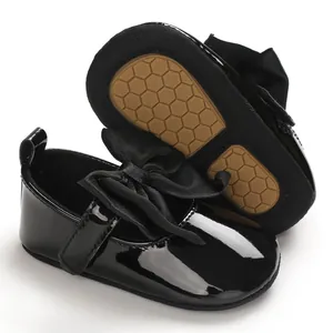 Vista detallada de los zapatos de bebé en charol negro con suela antideslizante