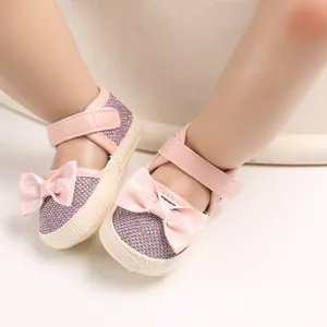 Close-up of stylish pink baby princess walking shoes featuring soft soles and a cute bow detail