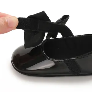 Primer plano de la correa con cierre de velcro en zapatos de charol negro para bebé niña