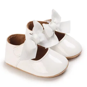 Detailansicht von weißen Lackleder-Babyschuhen für Mädchen mit eleganten großen Schleifen