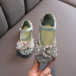 Elegant green dress shoes for girls featuring a sparkly rhinestone bow and faux pearls.