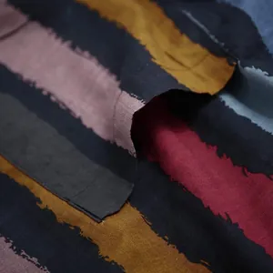 Nahaufnahme des Stoffes eines traditionellen Herrenrobens mit bunten Pinselstrich-Streifen