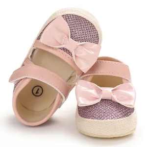 Detailed view of pink glitter baby girl princess shoes with glossy patent leather bow