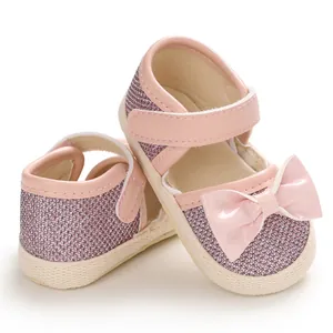 Close-up of pink glitter baby princess walking shoes with soft soles and glossy bow details