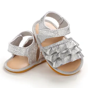 Silberne Glitzersandalen für Babys mit Rüschen und rutschfester Gummisohle.