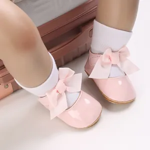Detail von rosa Babyschuhen für Mädchen mit Schleifenverzierung und weicher Sohle