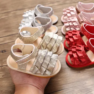 Detailansicht von glitzernden Babysandalen mit Rüschen und rutschfesten Gummisohlen für Babys.