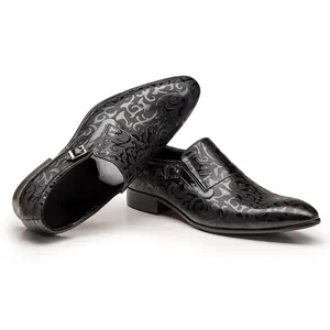 Detailed view of black men's dress shoes featuring intricate embossed swirl patterns.