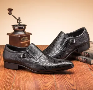 Detailed view of black men's dress shoes with embossed scroll pattern and metal buckle