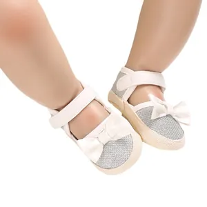 Sparkling silver baby walking shoes with white bow details and soft woven soles