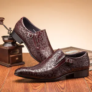 Detailed macro view of dark brown embossed leather shoes featuring a monk strap buckle closure.