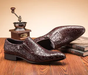 Detailed close-up of men's business leather shoes with intricate floral embossing and buckle.