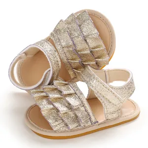 Detailansicht der gold glitzernden Babysandalen mit Rüschendekoration und Klettverschluss.