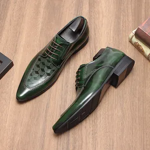 Detail van groene herenschoenen in leer met lasergegraveerd geometrisch kubuspatroon.