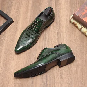 Detailopname van smaragdgroene leren herenschoenen met geometrisch lasergesneden patroon.