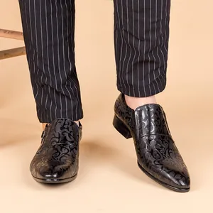 Detailed close-up view of black men's dress shoes with intricate baroque swirl texture