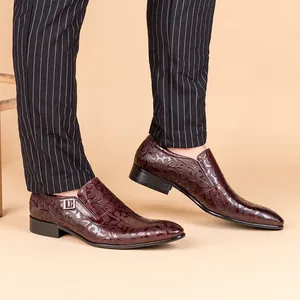 Detailed close-up of men's burgundy patterned leather dress shoes with buckle accent