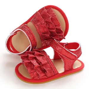Nahaufnahme roter Glitzer-Babysandalen mit niedlichen Rüschenschichten und weicher Sohle.