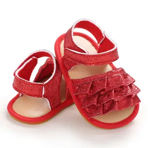 Detailansicht der roten Glitzer-Babysandalen mit Rüschendesign und Klettverschlussriemen.