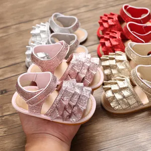 Nahaufnahme von glitzernden Baby-Lauflern-Sandalen mit Rüschen in verschiedenen Farben