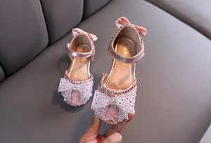Close-up detail of pink girls' princess shoes with sparkling rhinestones and bows
