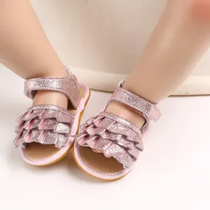 Nahaufnahme von rosa glitzernden Babysandalen mit Rüschendesign und rutschfester Sohle