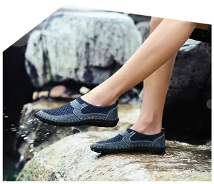 Close-up of blue breathable mesh slip-on shoes for men worn in a natural water stream