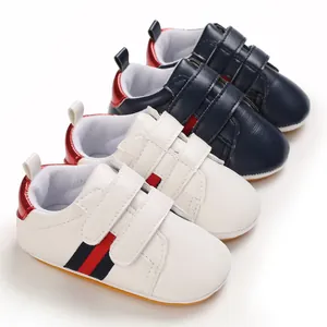 Close-up of white and navy baby walking shoes with adjustable Velcro straps