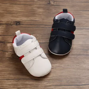 Close-up of white and navy blue baby pre-walker shoes with hook and loop straps