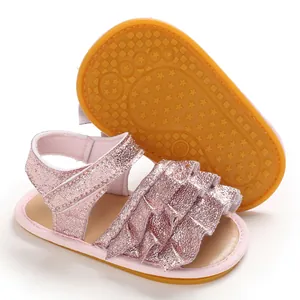 Detailansicht der rosa glitzernden Babysandalen mit Rüschen und rutschfester Gummisohle.