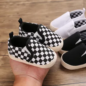Close-up of soft sole baby walking shoes in black white checkerboard and solid colors