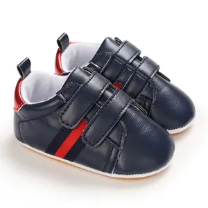 Detailed view of navy blue baby toddler shoes with red and navy stripes and Velcro straps.