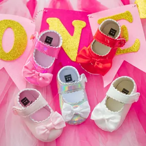 Plusieurs paires de chaussures de princesse pour bébé avec nœuds sur fond rose