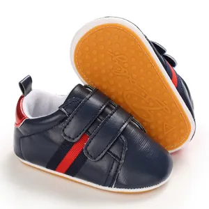 Detail view of navy baby walker shoes with non-slip yellow rubber sole and straps