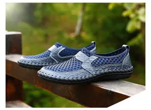 Detailed shot of blue breathable mesh slip-on shoes for men on a rustic wooden railing.