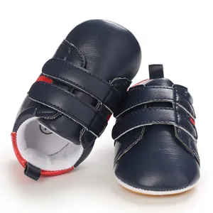 Close-up detail of navy blue baby boy walking shoes with red accents and soft soles