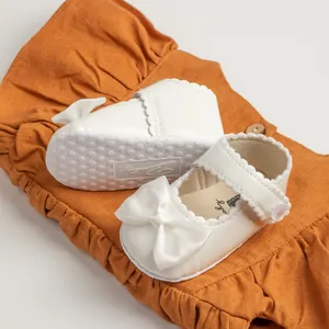 Vue détaillée de chaussures de princesse bébé fille en cuir verni blanc avec nœud et semelle souple