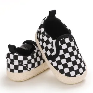 Detail showing the classic black and white checkerboard pattern on baby slip-on shoes