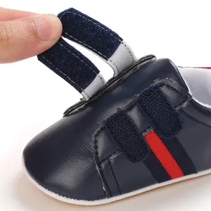 Close-up detail of navy blue toddler walking shoes showing dual velcro strap closure