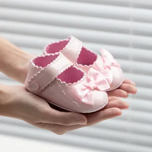 Vue détaillée de chaussures de princesse pour bébé en cuir verni rose avec nœud