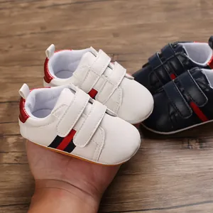 Close-up detail of white baby walking shoes with soft sole and striped design