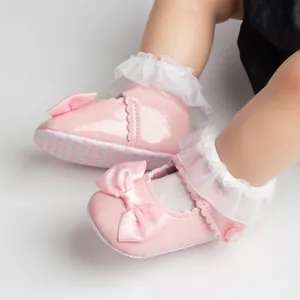 Chaussures de princesse roses pour bébé en cuir verni avec nœud et chaussettes en dentelle.